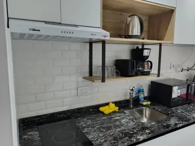 a kitchen counter with a sink and a microwave at Departamento Loft Cima del Cielo - Miralejos 16 Premium Resort in Villa Carlos Paz