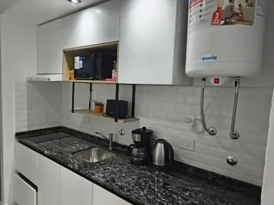 a kitchen counter with a sink and a microwave at Departamento Loft Cima del Cielo - Miralejos 16 Premium Resort in Villa Carlos Paz