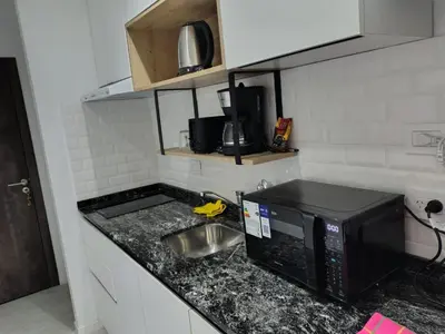 a kitchen counter with a microwave and a sink at Departamento Loft Cima del Cielo - Miralejos 16 Premium Resort in Villa Carlos Paz