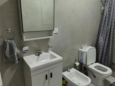 a bathroom with a sink and a toilet and a mirror at Departamento Loft Cima del Cielo - Miralejos 16 Premium Resort in Villa Carlos Paz