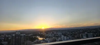 a view of the sun setting over a city at Departamento Loft Cima del Cielo - Miralejos 16 Premium Resort in Villa Carlos Paz