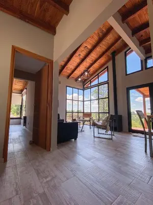 a large living room with wooden ceilings and large windows at Finca del Campito in Villa Berna