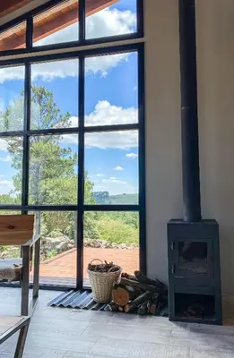 a fireplace in a room with a large window at Finca del Campito in Villa Berna