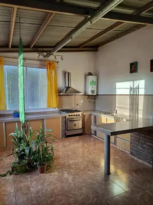 a large kitchen with a table in the middle at Departamento Barrio Escuela in Río Tercero