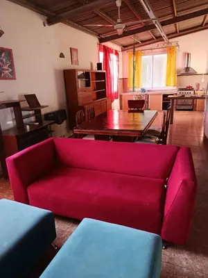 a living room with a red couch and a table at Departamento Barrio Escuela in Río Tercero