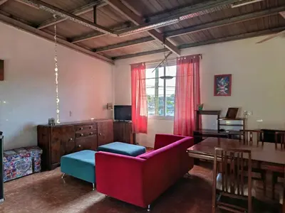 a living room with a red couch and a table at Departamento Barrio Escuela in Río Tercero