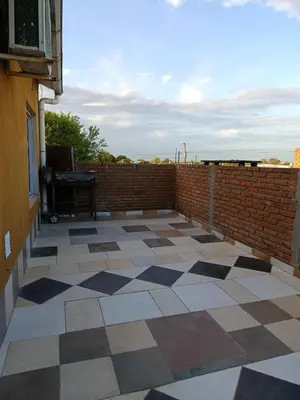 a patio with a brick wall and a tile floor at Departamento Barrio Escuela in Río Tercero