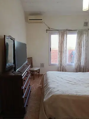 a bedroom with a bed and a flat screen tv at Departamento Barrio Escuela in Río Tercero