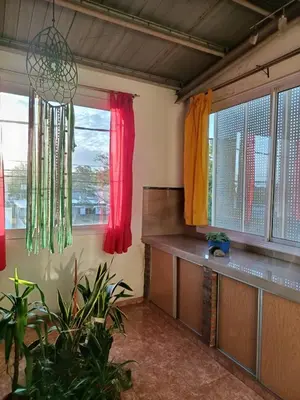 a room with two windows with red and yellow curtains at Departamento Barrio Escuela in Río Tercero