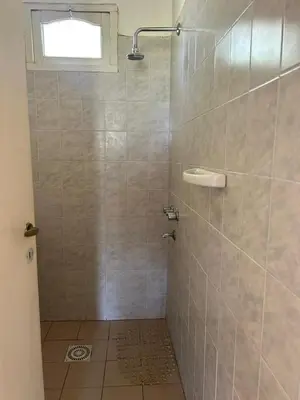 a bathroom with a shower with a tiled wall at Aiken Embalse in Embalse