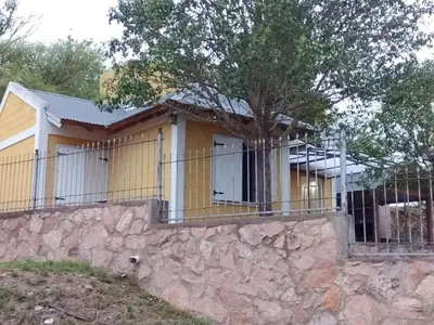 a house with a fence on a stone wall at Aiken Embalse in Embalse