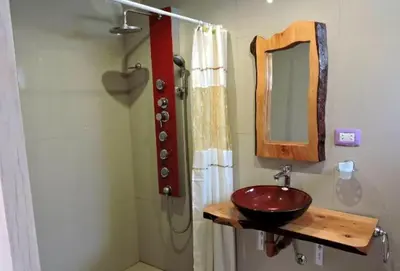 a bathroom with a red sink and a mirror at departamentos valle escondido in Villa Yacanto