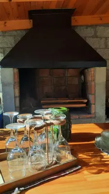 a group of wine glasses on a table in front of a fireplace at departamentos valle escondido in Villa Yacanto
