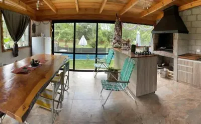 a large kitchen with a large wooden table and chairs at departamentos valle escondido in Villa Yacanto