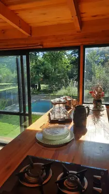 a kitchen with a stove top in a room with windows at departamentos valle escondido in Villa Yacanto