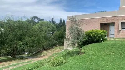 a house with a grass yard next to a building at Punta Serrana in La Paisanita
