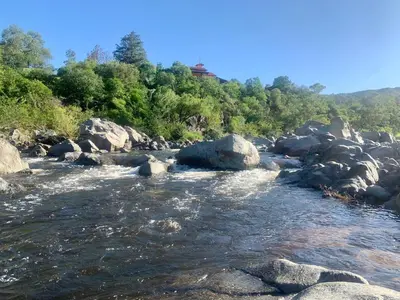 a river with rocks and trees in the background at Punta Serrana in La Paisanita