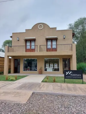 a building with a sign in front of it at Habitare Departamentos in Los Reartes