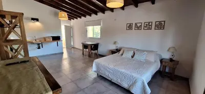 a bedroom with a bed and a table in it at Habitare Departamentos in Los Reartes