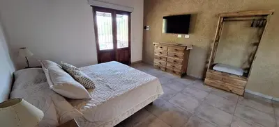 a bedroom with a bed and a dresser and a television at Habitare Departamentos in Los Reartes