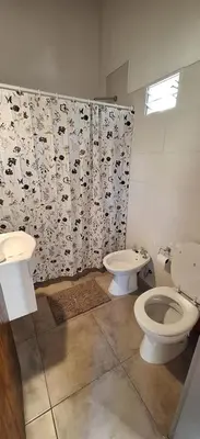 a bathroom with two toilets and a shower curtain at Habitare Departamentos in Los Reartes