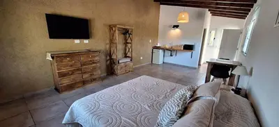 a bedroom with a bed and a flat screen tv at Habitare Departamentos in Los Reartes