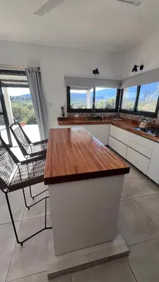 a kitchen with a table and chairs and windows at Sol & Río Refugio Serrano in Villa de Las Rosas