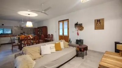a living room with a couch and a kitchen at Sol & Río Refugio Serrano in Villa de Las Rosas