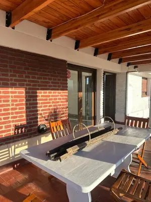 a large picnic table on a patio with chairs at lacasadelamontaña L&E in Villa Carlos Paz