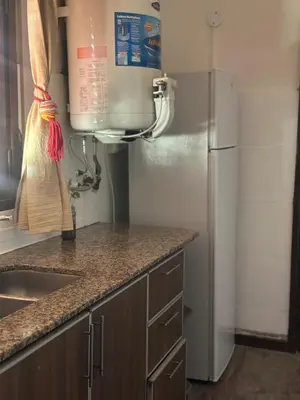 a kitchen with a sink and a refrigerator at lacasadelamontaña L&E in Villa Carlos Paz