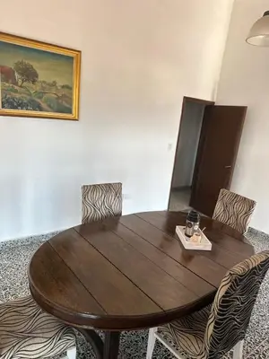 a wooden table with chairs and a plate of food on it at lacasadelamontaña L&E in Villa Carlos Paz