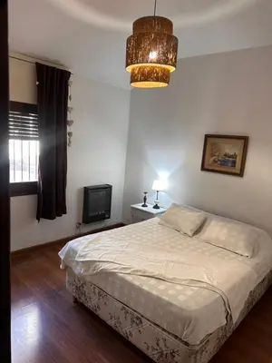 a bedroom with a bed and a chandelier at lacasadelamontaña L&E in Villa Carlos Paz