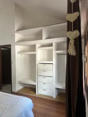 a bedroom with white shelves and a bed at lacasadelamontaña L&E in Villa Carlos Paz