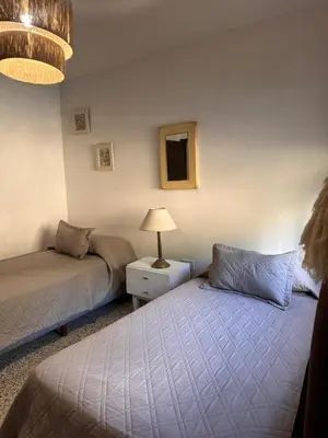 a bedroom with two beds and a lamp in it at lacasadelamontaña L&E in Villa Carlos Paz