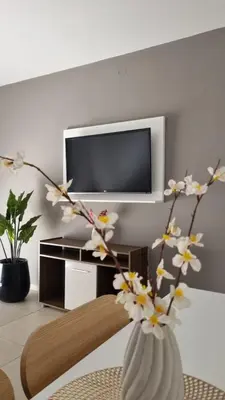 a living room with a vase with flowers in it at Garage y Gimnasio Depto Ideal Villa Dolores in Villa Dolores