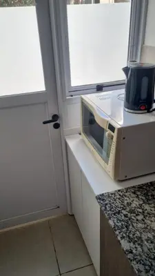 a microwave sitting on a counter next to a door at Garage y Gimnasio Depto Ideal Villa Dolores in Villa Dolores