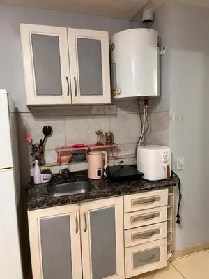 a kitchen with white cabinets and a counter top at Urban loft in Cordoba