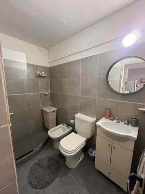 a bathroom with a toilet and a sink and a mirror at Urban loft in Cordoba