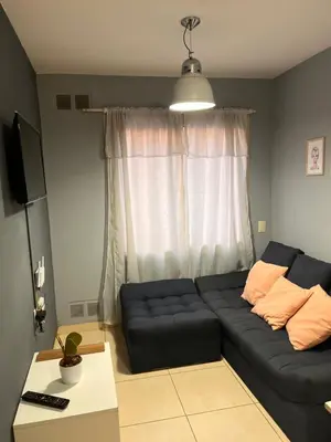 a living room with a black couch in front of a window at Urban loft in Cordoba