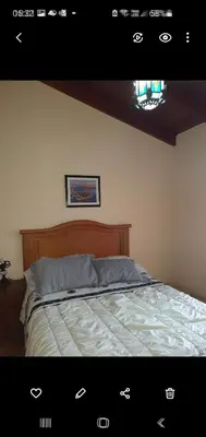 a bedroom with a bed with a wooden head board at Casa en las Sierras de Cordoba in Villa Parque Siquiman