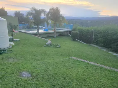 a yard with a swimming pool and a house at Casa en las Sierras de Cordoba in Villa Parque Siquiman