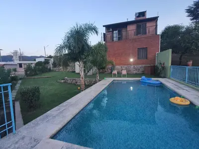 a swimming pool in front of a house at Casa en las Sierras de Cordoba in Villa Parque Siquiman