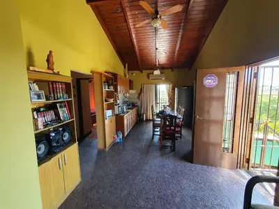 a living room with a ceiling fan and a kitchen at Casa en las Sierras de Cordoba in Villa Parque Siquiman