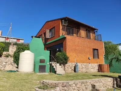 a brick building with a balcony on top of it at Casa en las Sierras de Cordoba in Villa Parque Siquiman