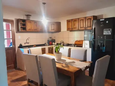 a kitchen with a table and chairs and a refrigerator at La casa de los abuelos! in Santa María