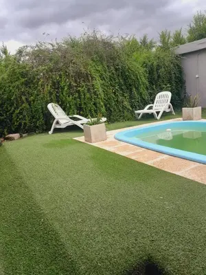 a yard with two lawn chairs and a swimming pool at La casa de los abuelos! in Santa María