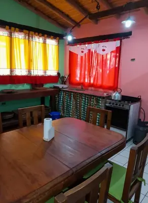 a kitchen with a wooden table and a stove at Cabaña para 8 en Arroyo de los Patos in Arroyo de Los Patos
