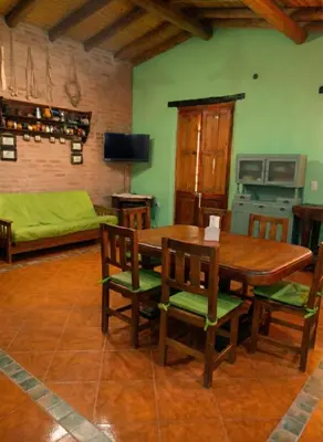 a dining room with a wooden table and chairs at Cabaña para 8 en Arroyo de los Patos in Arroyo de Los Patos