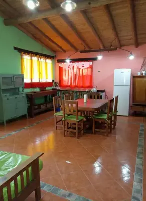 a kitchen with a table and chairs and a refrigerator at Cabaña para 8 en Arroyo de los Patos in Arroyo de Los Patos