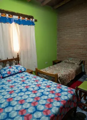 two beds in a room with green walls at Cabaña para 8 en Arroyo de los Patos in Arroyo de Los Patos